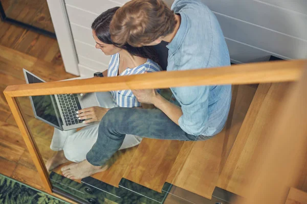 Feliz jovem casal trabalhando em cinza laptop — Fotografia de Stock