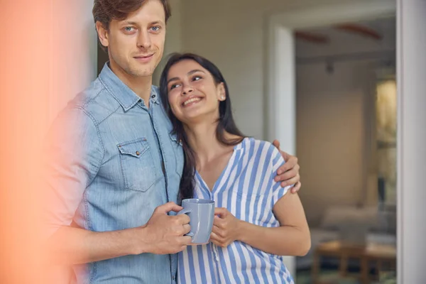 Leende man kramar sin flickvän i huset — Stockfoto