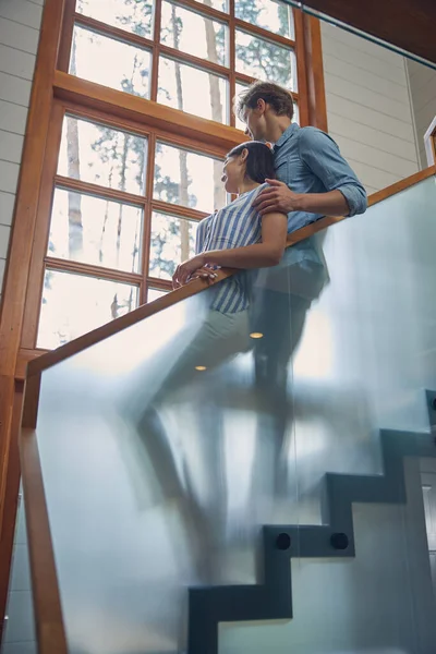 Evdeki ahşap merdivenlerde duran sevimli genç çift. — Stok fotoğraf
