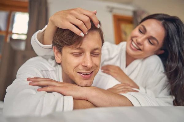 Gülümseyen kadın erkek arkadaşının saçına dokunuyor. — Stok fotoğraf
