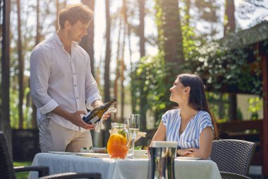 Yakışıklı adam elinde şarap şişesi tutuyor.