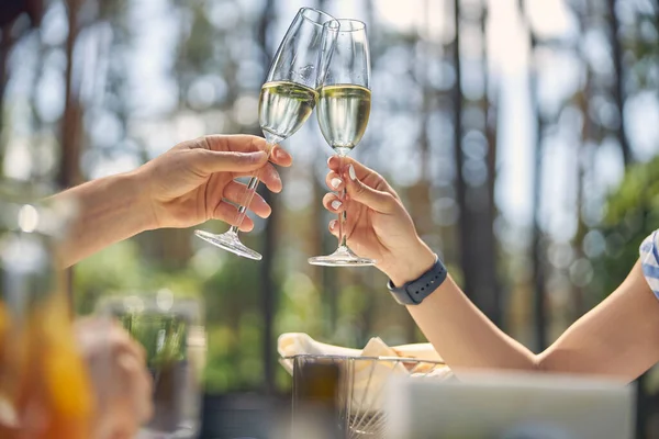 Szklanki wina w rękach pięknej pary, podczas gdy mają wielki czas relaksu — Zdjęcie stockowe
