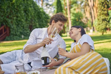 Adam parkta kadınına eğlenceli bir şeyler anlatıyor.