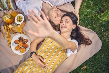 Sevimli kadın kollarını açarken tatlı adamın yanında yatıyor.