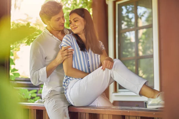 Glad leende man och kvinna sitter på uteplatsen i sitt hus — Stockfoto