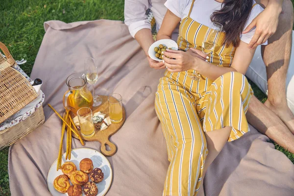 Retrato de una hermosa mujer sosteniendo el plato con aceitunas en las manos — Foto de Stock