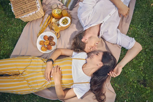 Stilig man tittar till sin vackra flickvän när han ligger i parken — Stockfoto