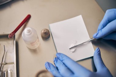Dolgu malzemelerini hazırlarken yardımcı doktorun elleri
