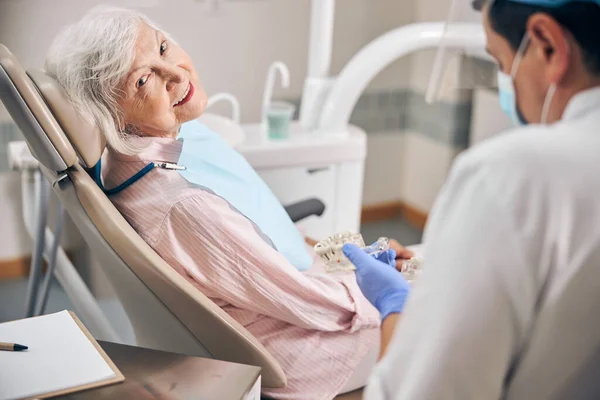 Dojrzały dentysta pracujący ze swoim starszym pacjentem — Zdjęcie stockowe