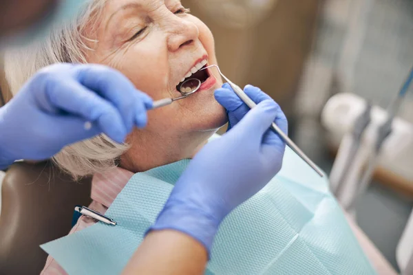 Verticaal beeld van vrouw patiënt vaststelling van haar tanden in moderne kliniek — Stockfoto