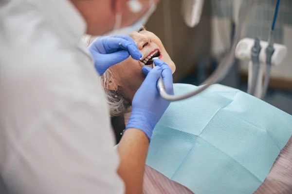 Mannelijke tandarts werkt samen met tandarts boor op patiënt — Stockfoto