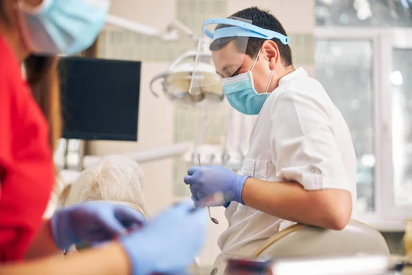 Οδοντίατρος με στολή στο χώρο εργασίας στο οδοντιατρείο — Φωτογραφία Αρχείου