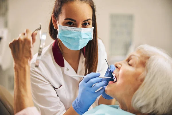Οδοντίατρος που εξετάζει τα δόντια των ασθενών στην οδοντιατρική κλινική — Φωτογραφία Αρχείου