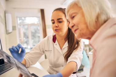 Kadınlar diş kliniğindeki imge dişlerine bakıyor.