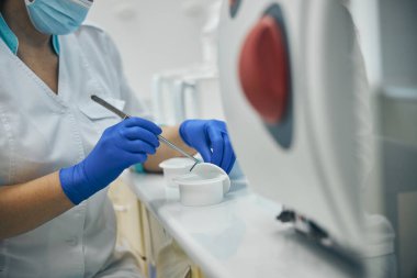 Mavi eldivenli kadın ilaç kullanıyor.