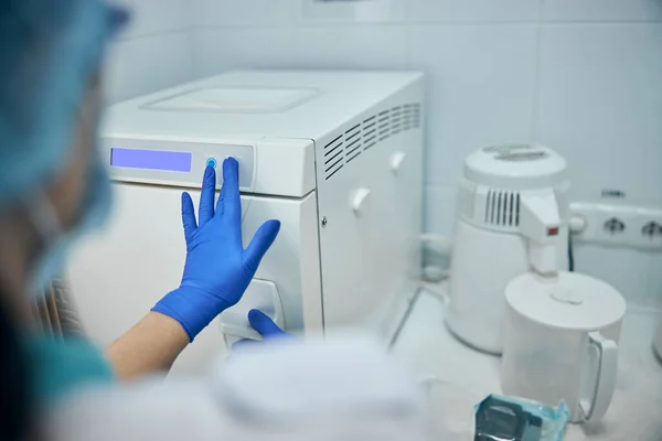 Vrouw is inclusief sterilisator machine aan het werk — Stockfoto