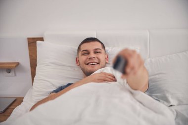 Yakışıklı beyaz adam yatak odasında iyi vakit geçiriyor.