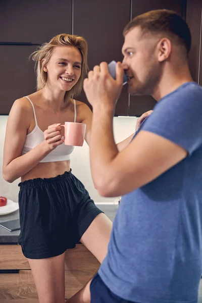 Unga familj par avkopplande i köket på morgonen — Stockfoto