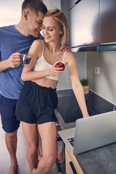 Jovem casal sorrindo passar tempo perto do computador — Fotografia de Stock