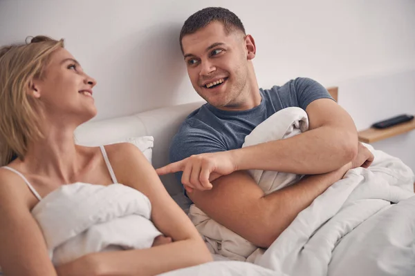 Beautiful married couple lies in bedroom laughing — Stock Photo, Image