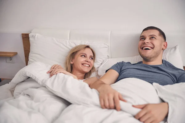 Joven pareja familiar disfrutando del tiempo juntos en el dormitorio —  Fotos de Stock