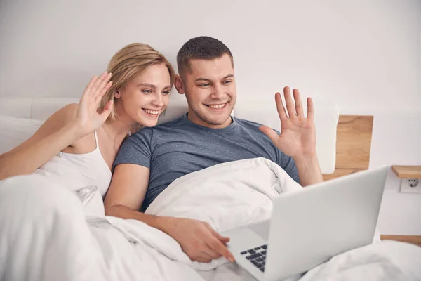 Feliz jovem casal passar tempo com gadget na cama — Fotografia de Stock