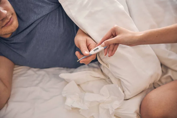 Manlig kontroll temperatur i sovrum med en annan person — Stockfoto