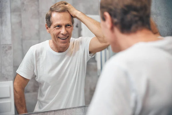 Male looking at himself in the mirror — Stock Photo, Image