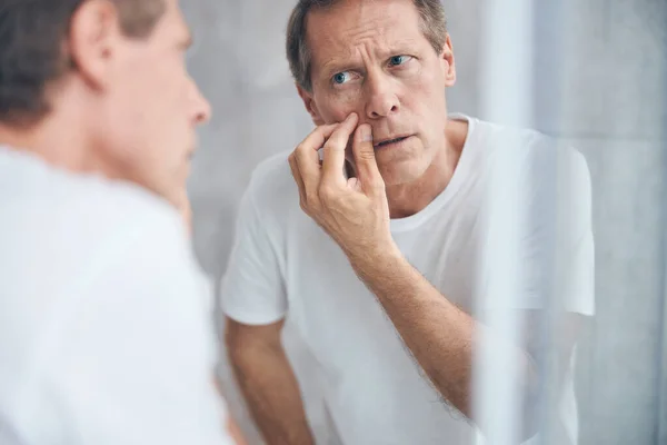 Serious man looking intently at his reflection — Stock Photo, Image