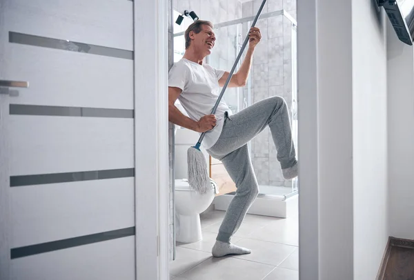 Alto espíritu masculino divirtiéndose durante la limpieza — Foto de Stock