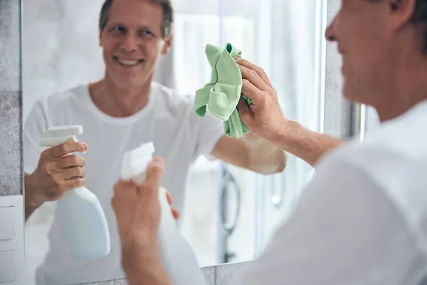 Focused photo on kind man wiping glass — Stock Photo, Image