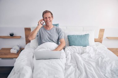 İş için dizüstü bilgisayar kullanan yakışıklı, gri saçlı adam.