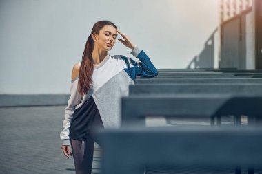 Hareketli giysili sakin bayan antrenmandan önce dinleniyor.