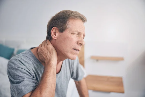 Upprörd mogen man som lider smärta i nacken — Stockfoto