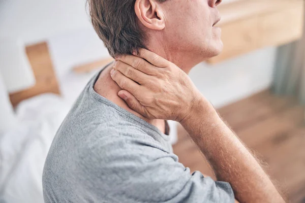 Close up of male hand touching neck — Stock Photo, Image