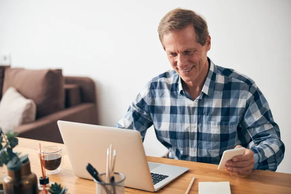 Handsome mature man staring at screen of his laptop — Stock Photo, Image