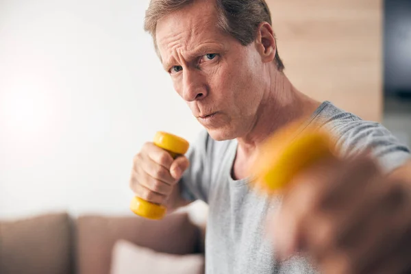 Zelfbewuste volwassen man die thuis sport doet — Stockfoto