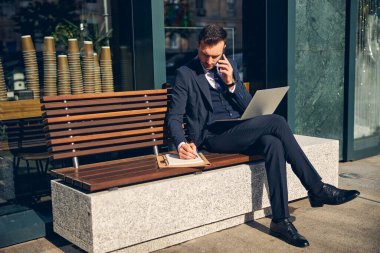 Yakışıklı genç adam, dışarıda sıcak havada yalnız çalışıyor.