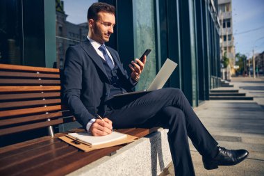 Yakışıklı beyaz erkek dışarıda aletlerle vakit geçiriyor.