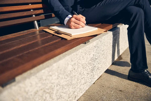 Άντρας που μένει έξω και σημειώνει πληροφορίες σε χαρτί — Φωτογραφία Αρχείου