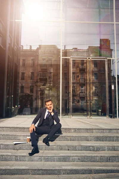Όμορφος μελαχρινός άντρας χαλαρώνει κοντά σε μεγάλο όμορφο κτίριο — Φωτογραφία Αρχείου