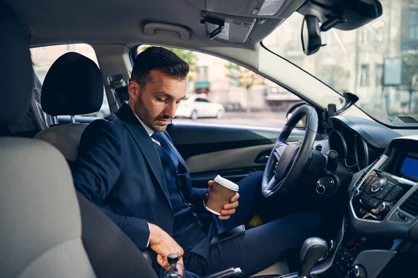 Attractive young man staying in auto alone — Stock Photo, Image