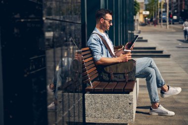Dikkatli sakallı adam aletine bakıyor.