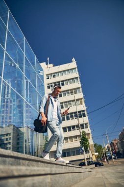 Dikkatli esmer adam aletinin ekranına bakıyor.