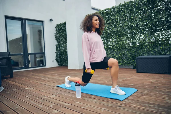 Menina bonita com cabelo encaracolado fazendo esporte — Fotografia de Stock