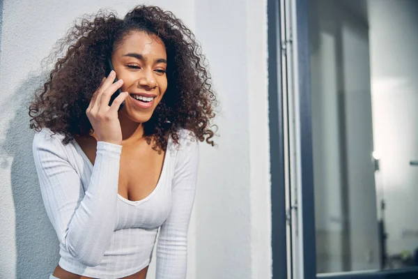 Morena feminina desfrutando de conversa agradável no telefone — Fotografia de Stock