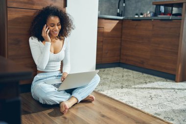 Kulağına zımbırtı dayamış gülümseyen kadın.