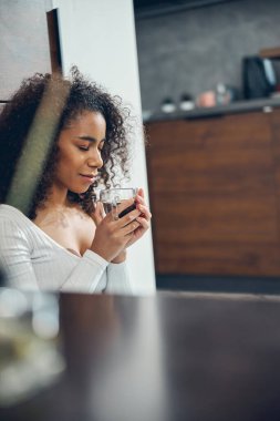 Sakin bir kadın kahve kokusunu içine çekiyor.