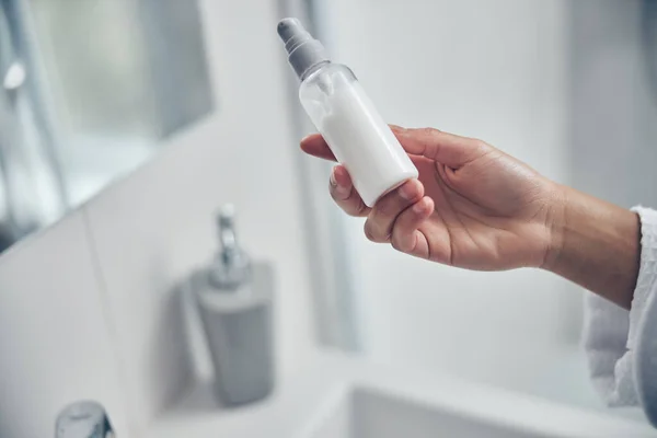 Mujer sosteniendo un producto cosmético en su mano — Foto de Stock