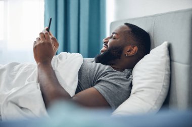 Rahatlamış genç bir erkek gelir mesajları okuyor.